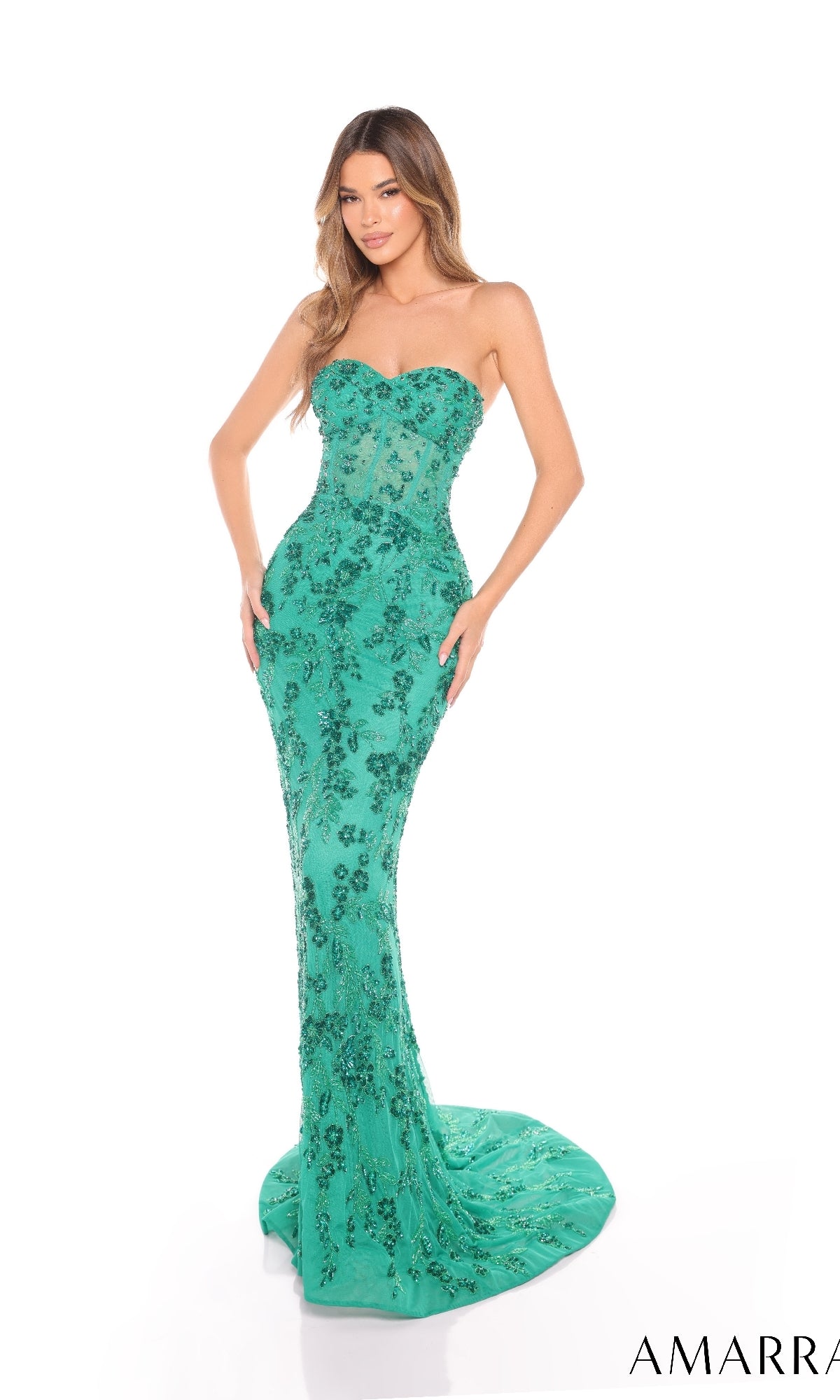 A woman models the Amarra 88236 long prom dress, a strapless, form-fitting gown with green sequin floral embellishments, standing against a white background.